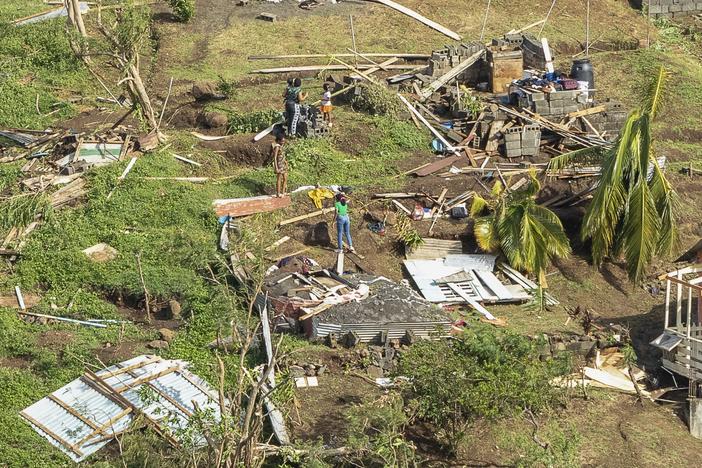 Family members survey their home destroyed by Hurricane Beryl, in Ottley Hall, St. Vincent and the Grenadines, on Tuesday. Beryl is the most powerful storm to form this early in the Atlantic hurricane season.