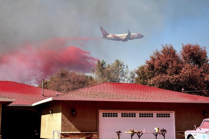 An air tanker drops fire retardant while trying to keep the Grubbs Fire from spreading in the Palermo community of Butte County, Calif., on Wednesday. Firefighters stopped the fire at around 10 acres, but the Thompson fire near Oroville, Calif., is still burning.