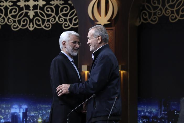 In this photo made available by Iranian state-run TV, IRIB, Iranian presidential candidate Saeed Jalili, left, a hard-line former nuclear negotiator, and reformist candidate Masoud Pezeshkian greet one another at the conclusion of a debate at the TV studio in Tehran, Iran, on June 1, 2024.