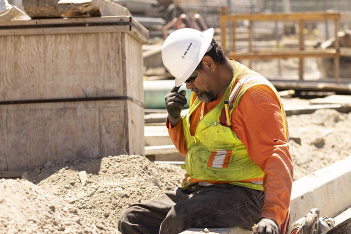 A worker adjusts his helmet on a construction site under the sun as southern California faces a heat wave, in Los Angeles, on Wednesday.