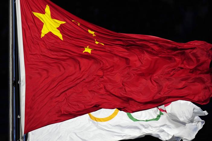 The Chinese and the Olympic flag wave during the opening ceremony of the 2022 Winter Olympics in Beijing. The World Anti-Doping Agency cleared 23 Chinese swimmers of doping allegations despite positive tests for banned substances, allowing them to compete in the 2021 Tokyo Games.