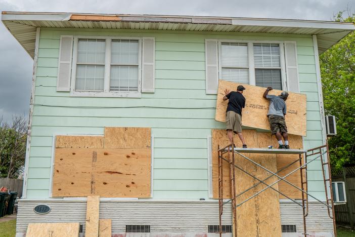 Dane Allen and Randy Davis board up apartments on Sunday ahead of Beryl's arrival in Corpus Christi, Texas.