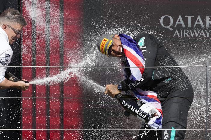 Mercedes driver Lewis Hamilton, right, celebrates on the podium after winning the British Formula One Grand Prix race at the Silverstone racetrack in Silverstone, England, on Sunday.