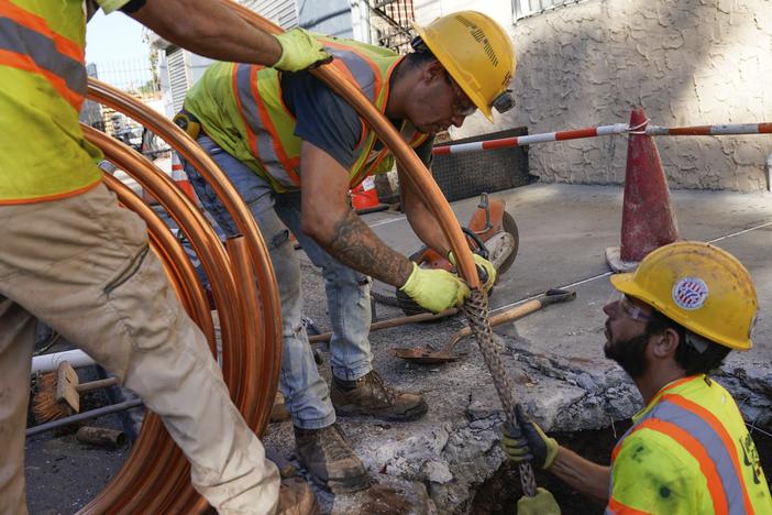 Workmen prepare to replace older water pipes with a new copper one in Newark, N.J., on Oct. 21, 2021.  