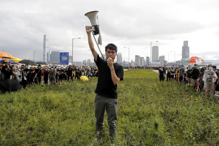 Roy Kwong Chun-yu, a pro-democracy member of Hong Kong's Legislative Council at the time, spoke over a loud-hailer to the police as he joined protesters in Hong Kong on July 1, 2019. Demonstrators pushed barriers and dumpsters into the streets in an apparent bid to block access to a ceremony marking the anniversary of the handover of the former British colony to China.