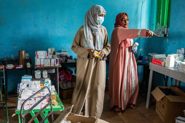 On July 6, volunteers dispense medication at a makeshift emergency clinic, set up in a former school in eastern Sudan, for people displaced by conflict.