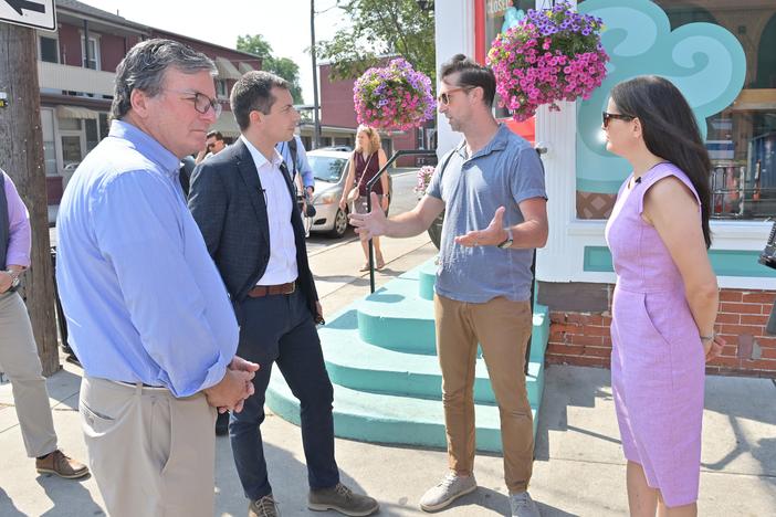 From left, Pennsylvania Secretary of Transportation Mike Carroll, U.S. Secretary of Transportation Pete Buttigieg, Dave Brown, owner of Splits and Giggles Cafe, and Lancaster, Pa., Mayor Danene Sorace speak next to one of the city's new protected bike lanes in June 2024. 