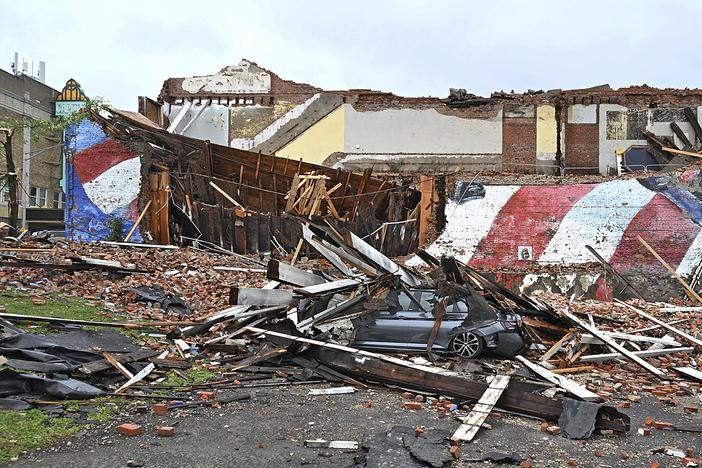 A car is crushed by a fallen building that hosted the Gansevoort mural that was struck by a tornado, in Rome, N.Y., on Tuesday. Much of the U.S. and Canada is cleaning up or still dealing with a new wave of severe storms that have caused deaths and damage this week from the Plains to New England.