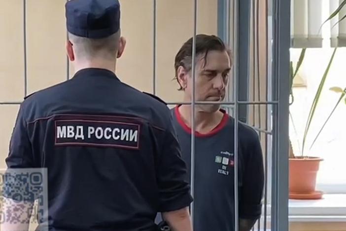 In this photo taken from video released by Khamovnichesky District Court press service on Thursday, U.S. citizen Michael Travis Leake stands in a cage in a Moscow courtroom before being convicted of drug trafficking charges and sentenced to 13 years in prison.