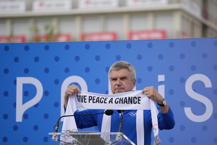 IOC President Thomas Bach holds a scarf during the inauguration of the Olympic Truce Wall in the Olympic Village at the 2024 Summer Olympics on Monday in Paris, France.