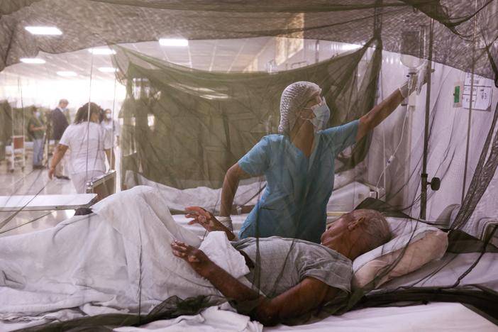 A nurse takes care of a dengue fever patient at the Sergio Bernales National Hospital in the outskirts of Lima on April 17. The number of suspected cases in Peru so far this year is over 100,000.