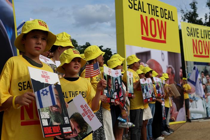 People hold pictures of Israeli hostages during a vigil on the National Mall on Tuesday in Washington, D.C. Families of hostages are hopeful Israeli Prime Minister Netanyahu will agree to a ceasefire deal that would bring the hostages home.