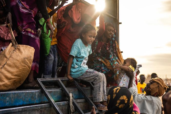 A Sudanese girl who has fled from the war with her family arrives at a refugee transit center. The conflict that began in April 2023 has displaced millions and created a humanitarian crisis.