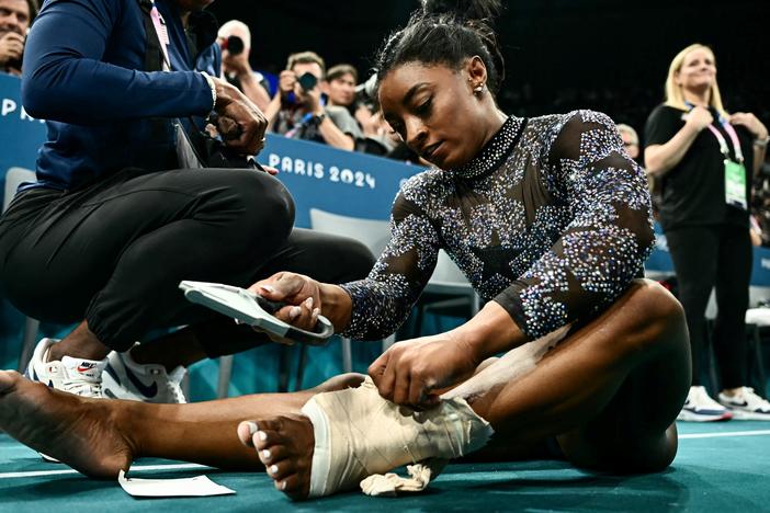 The U.S. gymnast Simone Biles appeared to hurt her lower left leg during a warmup on Sunday, but she finished the remaining events after wrapping her ankle with thick athletic tape. 