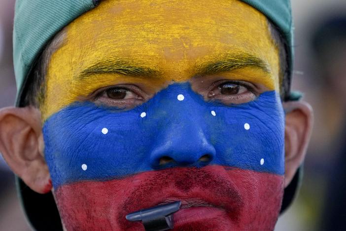 A Venezuelan living in Brasilia, Brazil, with his face painted in the colors of his nation's flag, gathers with fellow Venezuelans on the day of their nation's presidential election, Sunday, July 28, 2024. 