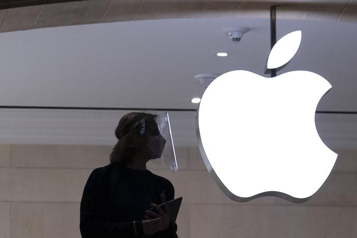 An Apple store employee stands inside the store in New York on Feb. 5, 2021. 