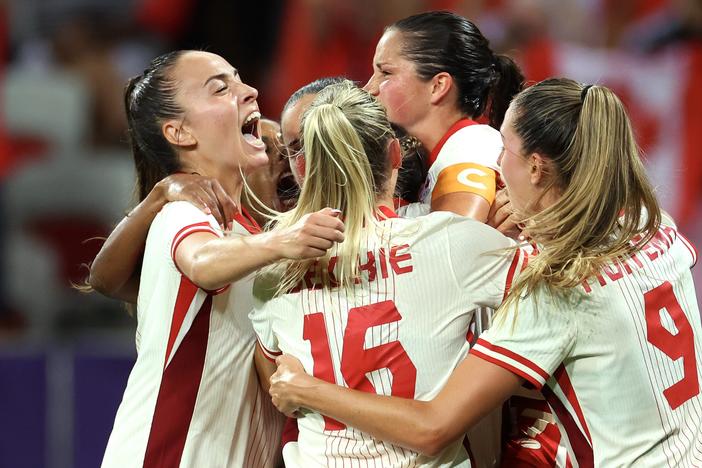 The Canadian women's soccer team celebrates during its win over Colombia Wednesday. The team has advanced into the Olympic quarterfinals amid an ongoing spying scandal involving the team's now-suspended head coach. 