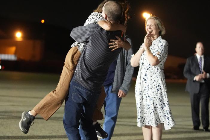Reporter Evan Gershkovich hugs his mother Ella Milman, left, at Joint Base Andrews, Md., following his release as part of a 24-person prisoner swap between Russia, the U.S. and several other countries on Thursday. Looking on at right is Elizabeth Whelan, sister of released prisoner Paul Whelan.