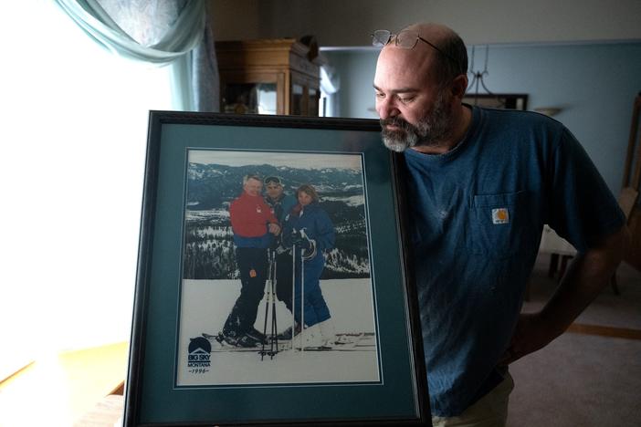 Casey Shively holds a photo of a family ski trip with his sister, Katie, and his father, Dan, in 1996. Dan Shively died in a memory care home after being violently attacked by another resident.