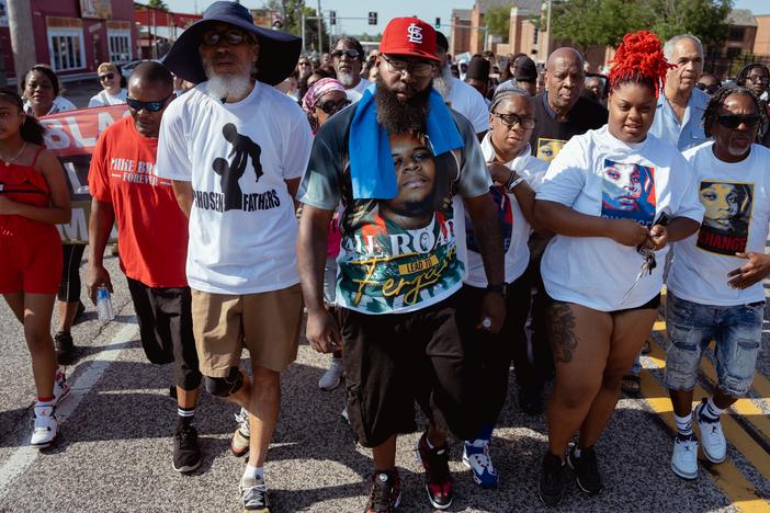 Michael Brown Sr., center, leads a unity march commemorating a decade after Michael Brown Jr.’s police killing on Friday, Aug. 9, 2024, outside of Normandy High School in Normandy. Michael Brown Jr., his son, was killed by a Ferguson police officer in 2014 only days after graduating from high school.