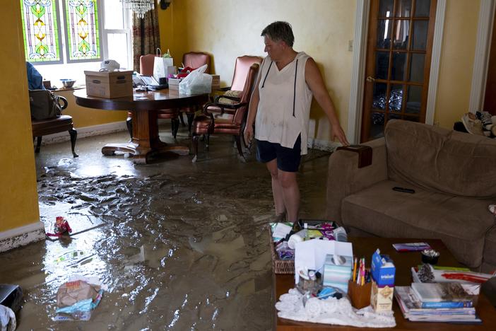 Ann Farkas walks in her flood-damaged home in Canisteo, N.Y., Friday, after remnants of Tropical Storm Debby swept through the area, creating flash flood conditions in some areas.