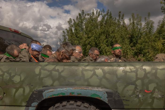 A Ukrainian military vehicle filled with captured Russian troops travels on the Ukrainian side of the border with Russia on Tuesday. Ukraine's President Volodymyr Zelenskyy says Ukraine has captured hundreds of Russian fighters since it launched its invasion into the Kursk region of western Russia on Aug. 6.
