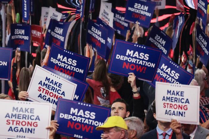 Attendees at the Republican National Convention hold up signs reading "Mass Deportation Now!" last month in Milwaukee.