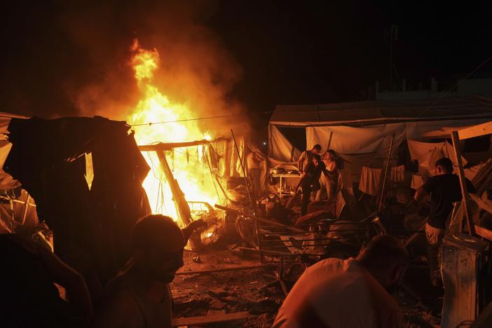 Palestinians react to fire from an Israeli strike that hit a tent area in the courtyard of Al Aqsa Martyrs hospital in Deir al Balah, Gaza Strip, on Sunday. The strike killed several people including a woman and injured others, health officials confirmed.