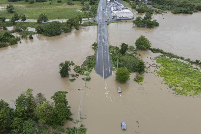 The La Plata River floods a road Wednesday after Tropical Storm Ernesto passed through Toa Baja, Puerto Rico.
