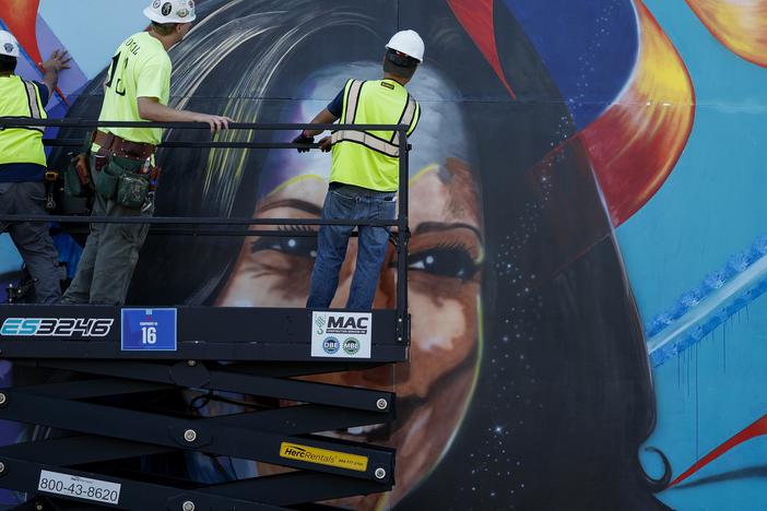 Ahead of the Democratic National Convention, workers construct a mural of Vice President Harris outside of Chicago's United Center in Chicago on Aug. 16, 2024.