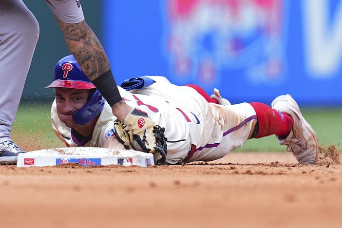 Austin Hays of the Philadelphia Phillies slides in safely past Gleyber Torres of the New York Yankees on July 31, 2024. The Yankees defeated the Phillies 6-5 that day.