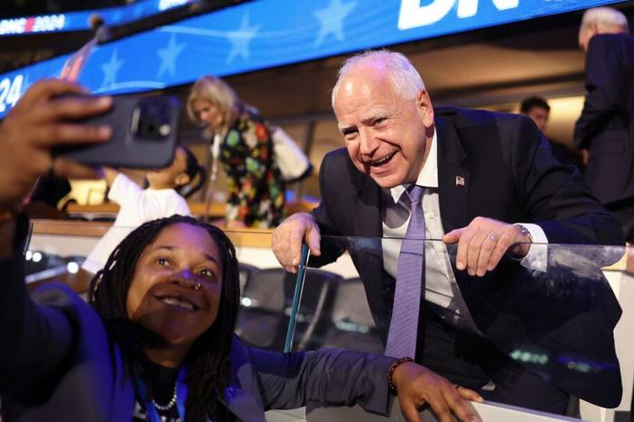 Minnesota governor and 2024 Democratic vice presidential nominee Tim Walz poses for pictures with an attendee on the first day of the Democratic National Convention at the United Center in Chicago on Monday. Walz is addressing the convention on Wednesday to accept the party's nomination.