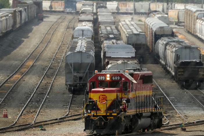 A worker climbs aboard a locomotive at a CPKC rail yard on Wednesday, Aug. 21, 2024, in Kansas City, Mo.