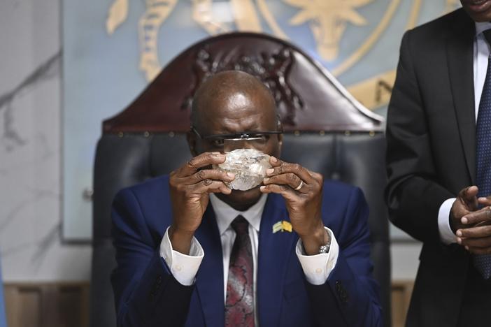 Botswana's President Mokgweetsi Masisi holds the 2,492-carat diamond that was unearthed at one of its mines and will be put on show, on Thursday, Aug. 22, 2024, in Gaborone.