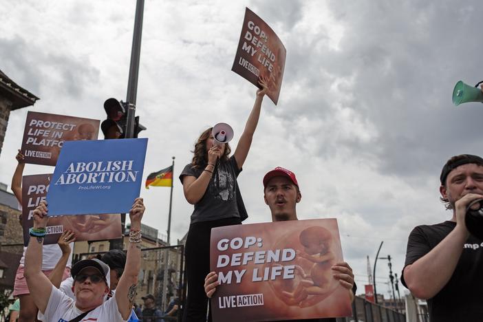 Anti-abortion protesters stand outside of the Republican National Convention in Milwaukee in July. Wisconsin reverted to an 1800s abortion ban when <em>Roe </em>was overturned. The courts have since reinstated some abortion access in Wisconsin.