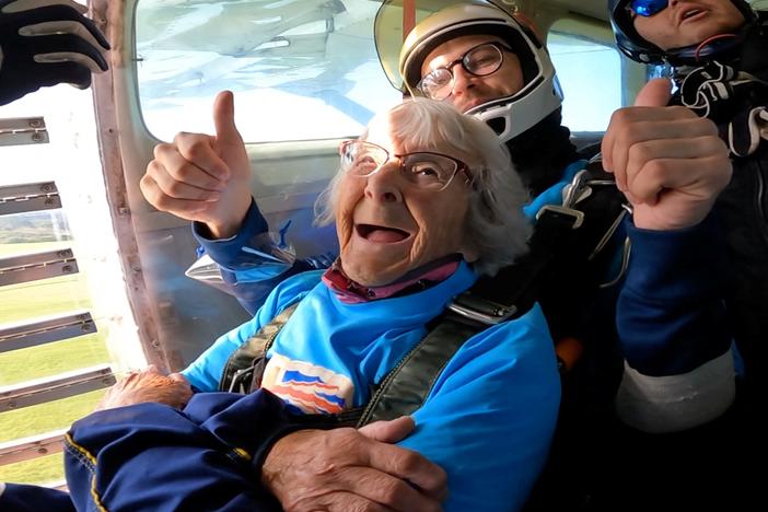 In this screengrab taken from a handout video, Manette Baillie, 102, smiles as she prepares to skydive over England on Sunday.