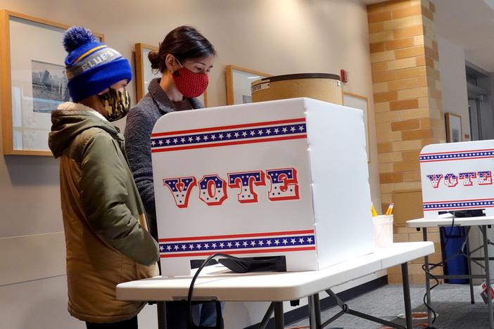 Marie Guenther votes at the Bay View Library with her son in October 2020 in Milwaukee, Wis., considered a battleground state.