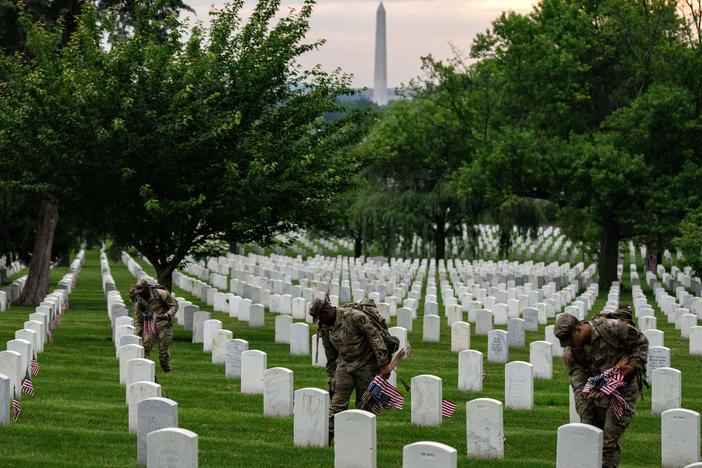 Members of the 3rd U.S. Infantry Regiment, also known as the "Old Guard," place flags at the headstones of U.S. military personnel buried at Arlington National Cemetery ahead of Memorial Day, on May 23, 2024 in Arlington, Virginia. 