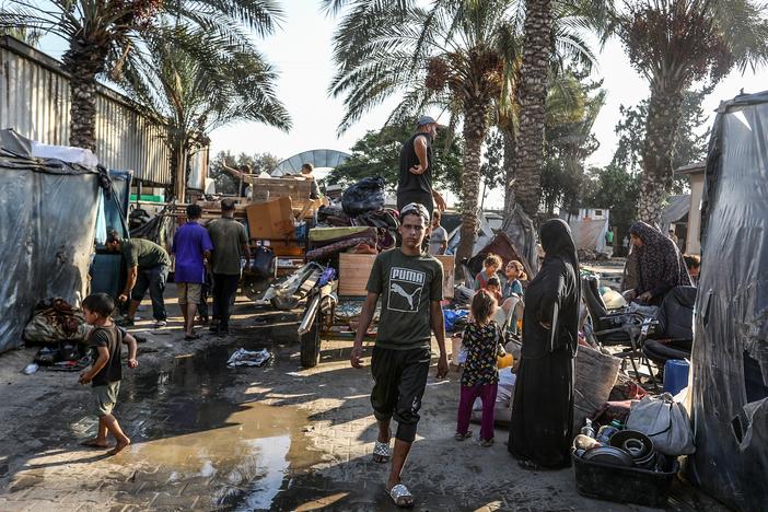 Palestinians carry their belongings on their way to migrate for safer areas following the Israeli army's warning to evacuate the Dawa Faculty of the Ministry of Endowments in Deir al-Balah, Gaza, on Monday.