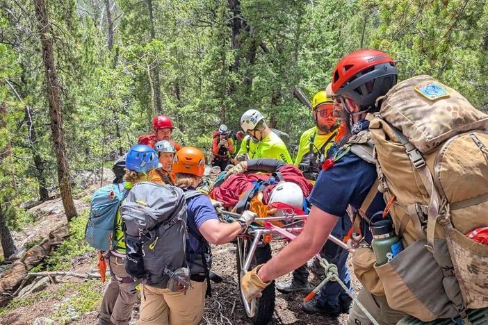 Search and rescue teams used a litter on an all-terrain wheel to bring a stricken hiker to safety. The man had inadvertently been left behind on an office retreat hike.