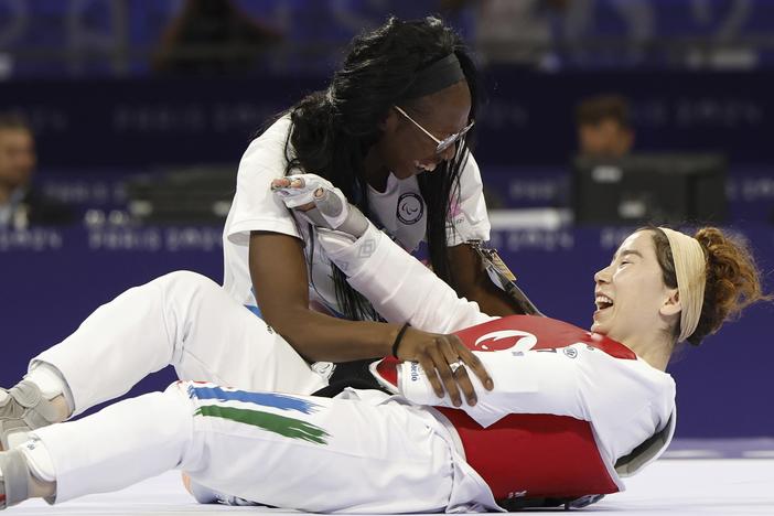 Zakia Khudadadi from the Paralympic Refugee Team, bottom, celebrates her bronze medal in Para Taekwondo during the Paralympic Games in Paris, Thursday, Aug. 29, 2024. 