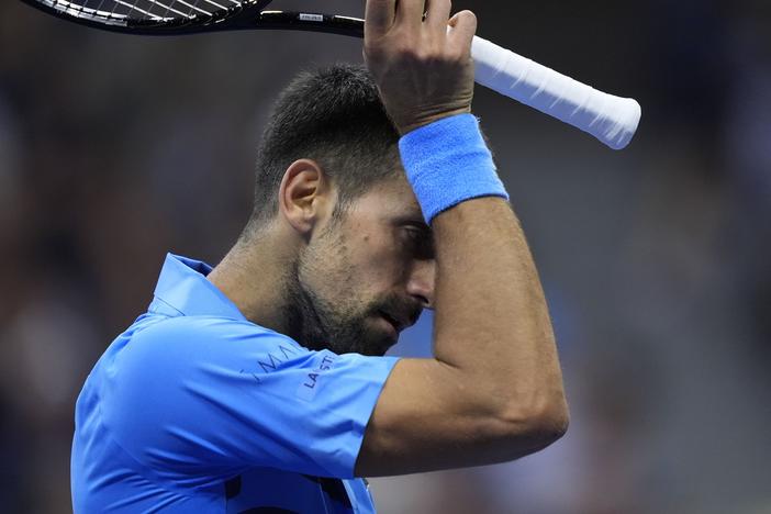 Novak Djokovic of Serbia wipes his face against Alexei Popyrin of Australia during a third round match of the U.S. Open tennis championships on Friday.