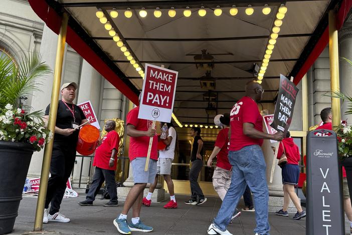 Hotel workers on strike chant and beat drums while picketing outside the Fairmont Copley Plaza hotel on Sunday in Boston.