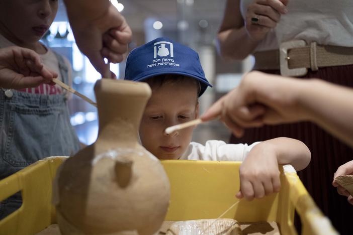 Ariel Heller, 4, helps to glue a broken clay jar during a special tour with his family after he accidentally broke another jar at the Reuben and Edith Hecht Museum in Haifa, Israel, on Friday. The boy who accidentally broke a rare 3,500-year-old jar in an Israeli museum has been forgiven and invited back, as curators hope to turn the disaster into a teachable moment.