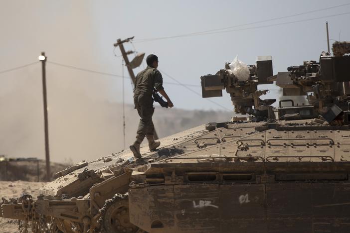 An Israeli soldier walks on a tank near the border of the Gaza Strip in southern Israel on Aug. 21.