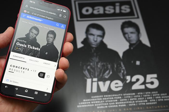 A fan uses a smartphone to access an online ticket sales website to purchase tickets for Oasis' "Live '25" tour. Oasis fans queued online early Saturday to buy tickets for the eagerly awaited reunion tour, but many tickets had already been scooped up by resellers charging many times over original ticket prices.