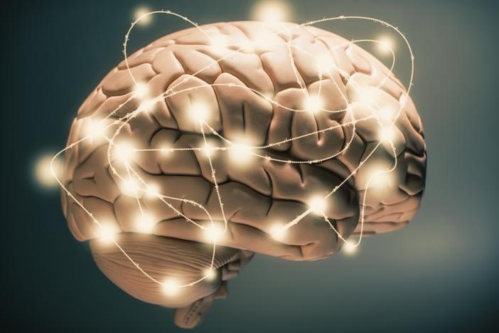 Glowing lines and spots encircling a human brain