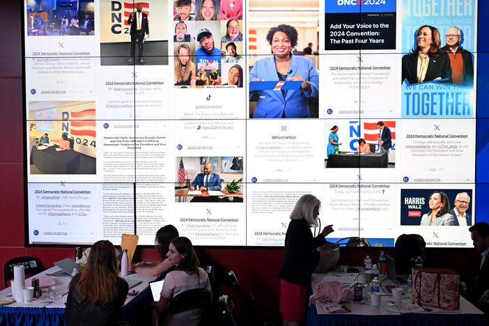 People sit next to a content creators wall on the third day of the Democratic National Convention at the United Center in Chicago in August.