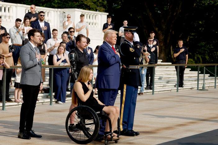Former President Donald Trump looks on alongside Marlon Bateman (left), Marine Cpl. Kelsee Lainhart and U.S. Marine Corps Sgt. Tyler Vargas-Andrews during a wreath-laying ceremony at Arlington National Cemetery on Aug. 26 to honor the lives of those who died at the Abbey Gate bombing in Afghanistan.