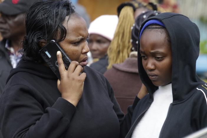 Distressed parents and relatives stand near a burned-out dormitory, following a fire at the Hillside Endarasha Primary in Nyeri, Kenya Friday, Sept. 6, 2024. (AP Photo)